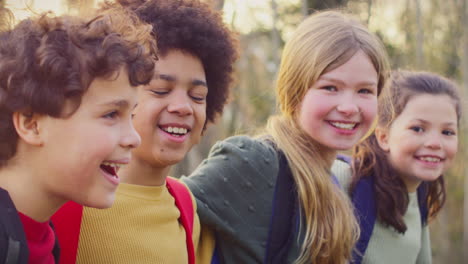 portret van kinderen met schoolrugzakken buiten met armen om elkaar heen