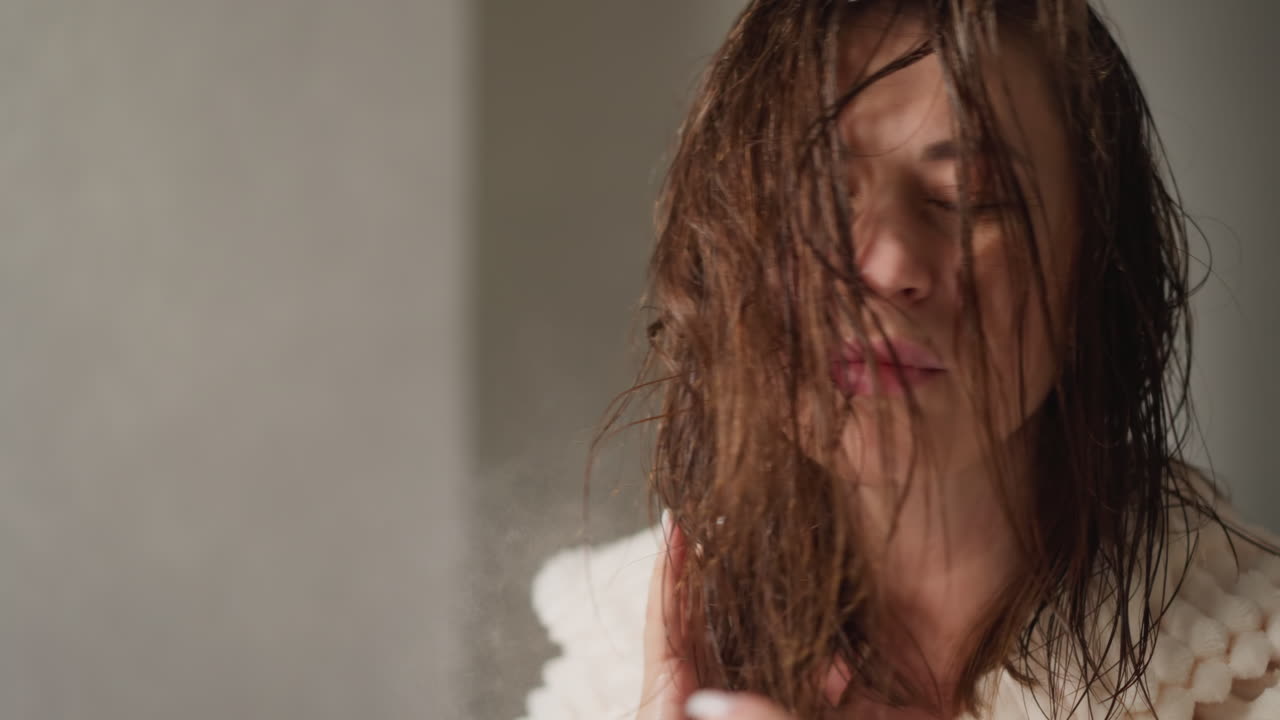 una mujer bonita hidrata el cabello mojado con una emulsión eficaz en la ducha a cámara lenta. sprays de aerosol muy eficaces para suavizar el cabello en la ducha