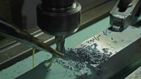 rotating tool cuts metal block with coolant flow in precision milling process