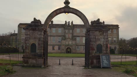 Panning-view-over-the-arched-entrance-to-Lyme-house-in-Disley,-Cheshire,-UK