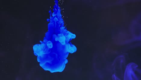 slow motion video of blue watercolor ink mixing in water against black background