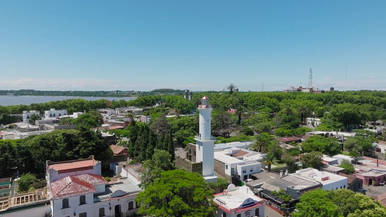Ripresa lenta con drone in orbita attorno al faro di Colonia del Sacramento, Uruguay. Giornata di sole limpida. Storico punto di riferimento coloniale.