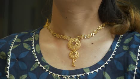 young asian woman wearing designer gold necklace, 18k huid certified gold necklace, closeup
