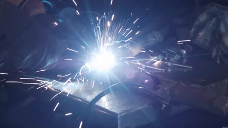 sparks as man arc welds metal in garage