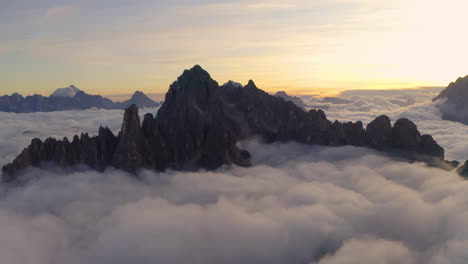 Ethereal-clouds-surrounding-Tre-Cime-Dolomites-mountains-orbiting-South-Tyrol-sunrise-landscape-aerial-view