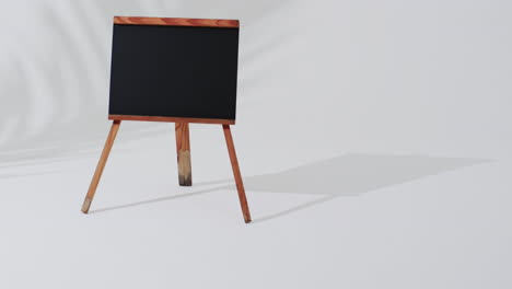 video de un letrero de pizarra en un soporte de madera con espacio de copia en un fondo blanco