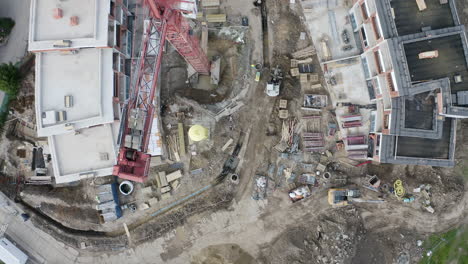 vista aérea de grúas de acero rojas en un sitio de construcción residencial