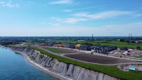 Nuevas-Casas-Adosadas-En-Construcción-En-Un-Desarrollo-De-Viviendas-Comunitarias-Junto-Al-Lago-Cerca-De-Tierras-De-Cultivo-En-Ontario