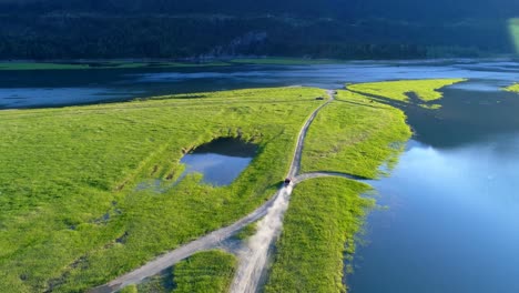 Fahrzeug-Fährt-Auf-Unbefestigter-Straße-In-Der-Nähe-Des-Seeufers-4k