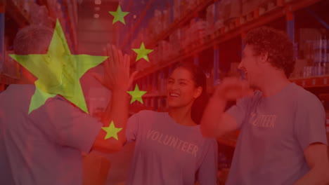 animation of flag of china over diverse male and female volunteers high fiving in warehouse