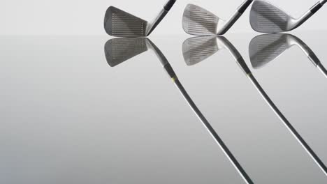 Close-up-of-golf-clubs-on-white-background,-copy-space,-slow-motion