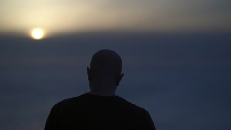 Silhouette of a man smoking at sunset