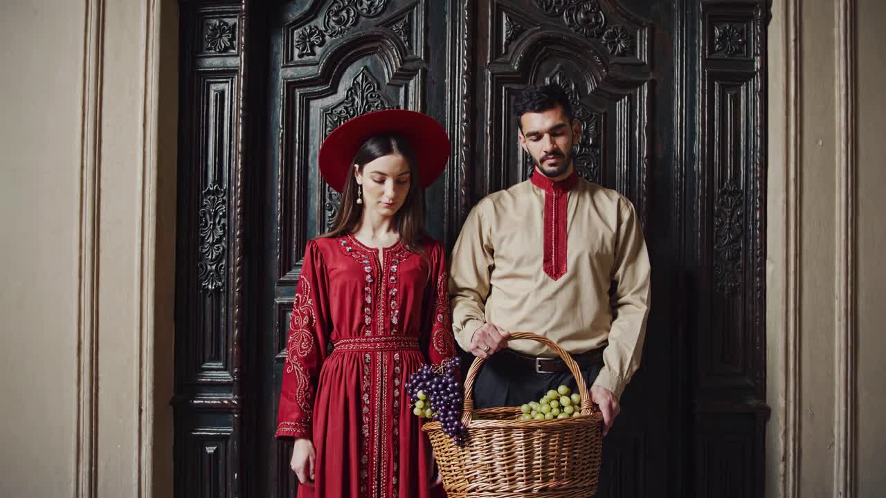 Couple in Traditional Attire with Grapes