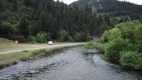 drone shot approaching a man fly fishing in the provo river in the mountains of utah