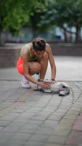 woman playing with her pug in a park