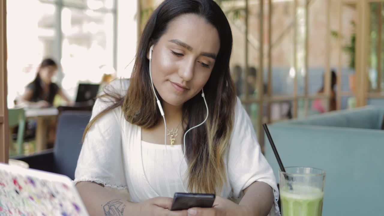 mujer joven viendo un video en el teléfono móvil