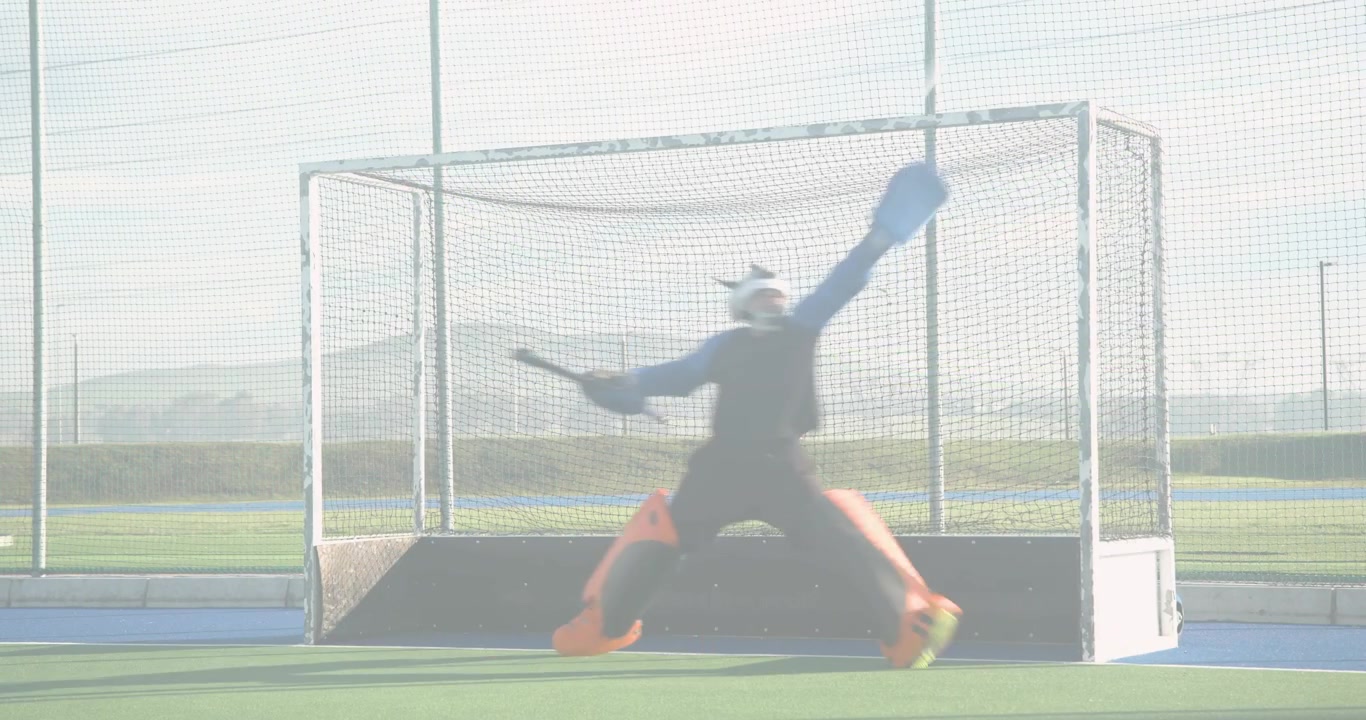 Field hockey goalkeeper positioning and deflecting incoming colored beams on turf sports training