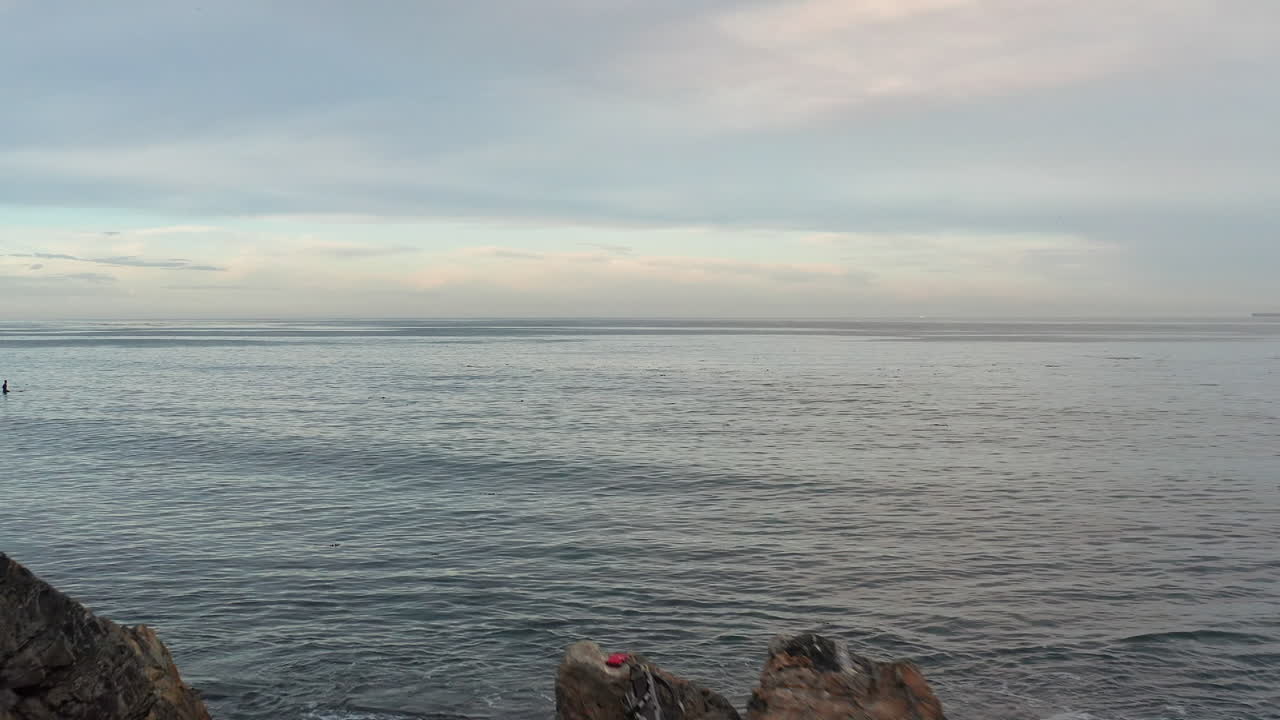 해변에서 한 여성의 비행을 한 다음 해가 질 때 끝없는 바다 지평선을 향해