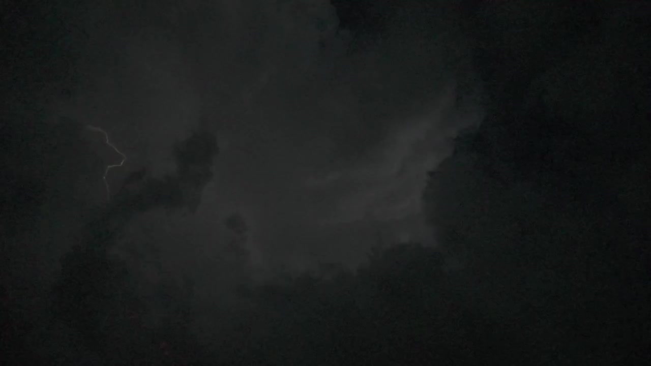Temporale con fulmini che lampeggia tra le nuvole temporalesche in una notte buia.