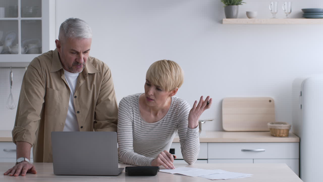 Coppia che discute di finanze in cucina