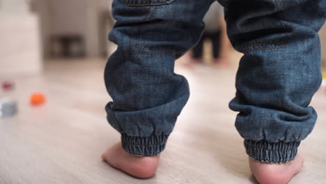 rear view of a barefoot baby taking his first steps