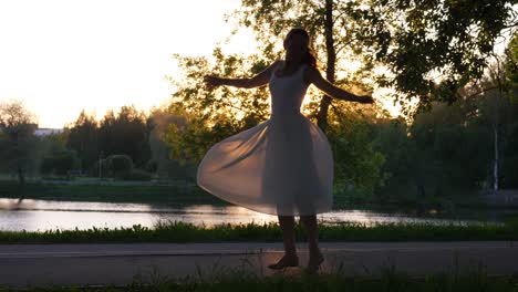 happy woman dancing in park at sunset