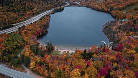 Antenne-Des-Blauen-Sees-In-Den-Bergen,-Umgeben-Von-Herbstlaub