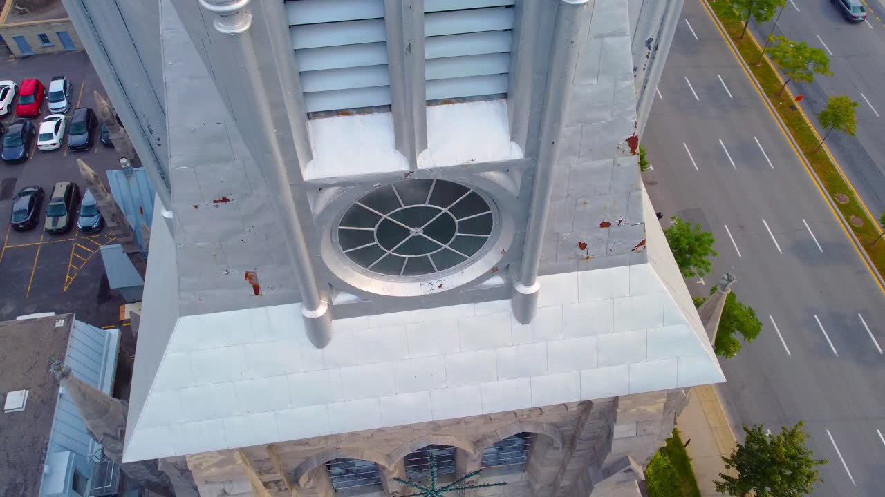 Drone slowly descends with top-down view and orbits Church Steeple tower in Montreal Canada
