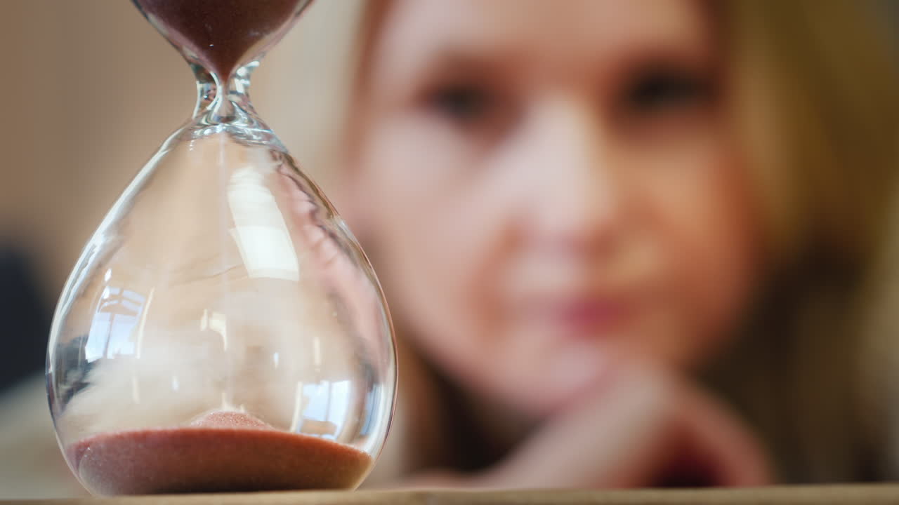 женщина смотрит на песочные часы 1