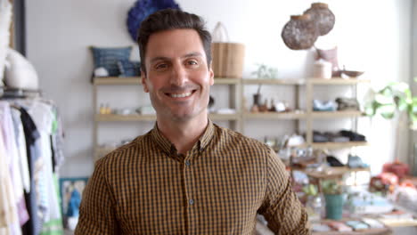 smiling male business owner in boutique walks into focus