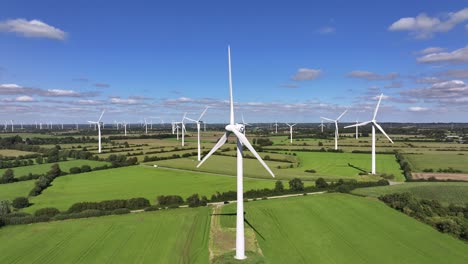 wind turbines farming wind energy, green fields, blue sky, countryside, sunny, slow pull in movement, symbolic, picturesque