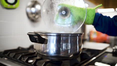 liberación de vapor de una olla hirviendo en la estufa en la cocina