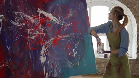 mujer crea una obra maestra de pintura abstracta, salpica pinturas en el lienzo