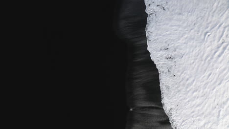 aerial tilt shot over the the stokksnes black sand beach, winter day in iceland