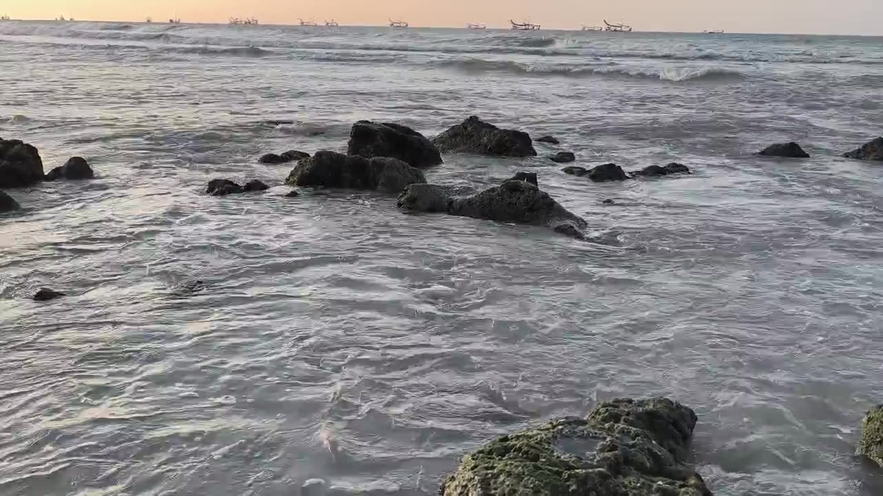 Onde dell'oceano che si infrangono contro le rocce al tramonto