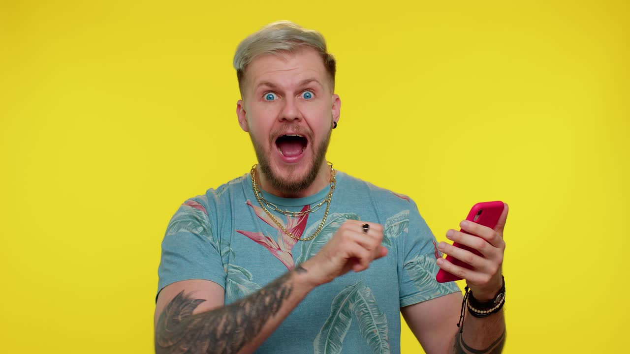 행복한 흥분한 남자가  ⁇ 드폰을 사용해서 "와우"라고 말했어요.