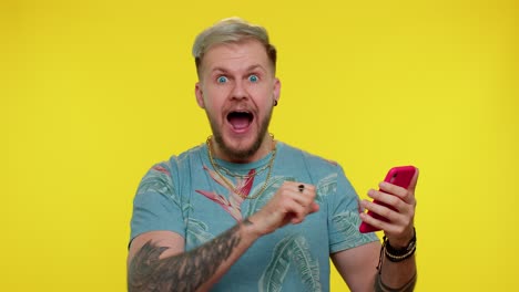 hombre feliz emocionado utilizar el teléfono móvil decir wow sí descubrió gran gran ganancia noticias haciendo el gesto ganador