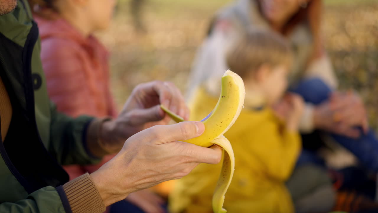 Family enjoying a banana snack during an autumn picnic