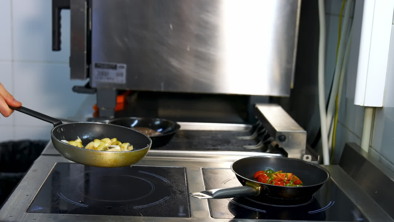 Delicious fried mushrooms in a frying pan. Unrecognizible chef turns mushrooms in frying pan. Modern restaurant kitchen background.