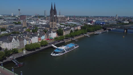 Drone-shot-of-the-Kölner-Dom-next-to-Rhine-river---drone-is-flying-sideways-facing-the-dome-and-tv-tower