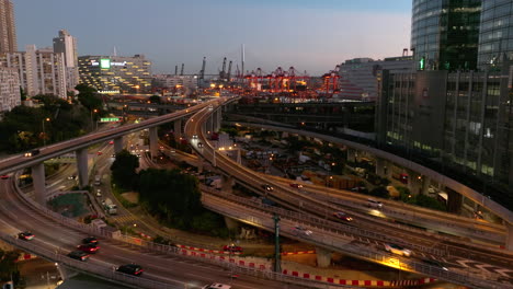 Ascending-aerial-view-of-Traffic-Network-in-Kwai-Chung-District-after-sunset---industrial-port-of-Hong-Kong-City-in-background