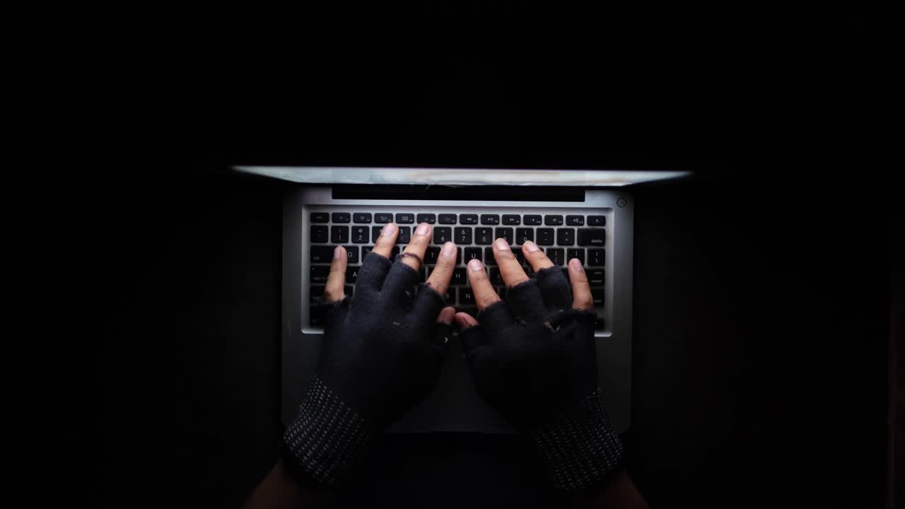 Hacker che digita su un laptop al buio
