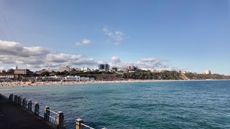 bournemouth beach and pier on sunny summer day with blue sky, clouds and calm sea