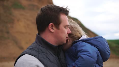 father and daughter embrace at the beach