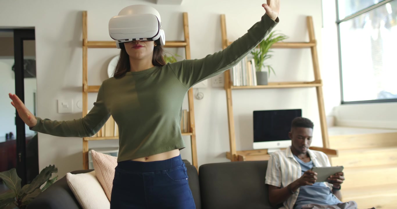Una donna della coppia che indossa un visore VR bianco, naviga un'interfaccia virtuale dopo l'attivazione del visore a casa.