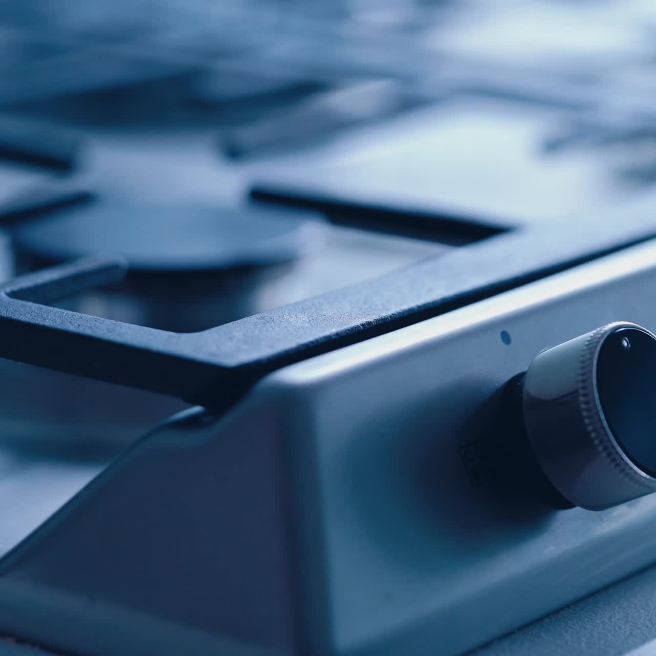 Switching on the gas cooker. Female's hand turning on the gas on a stove. Fire lights up on the electric cooker. Close-up.