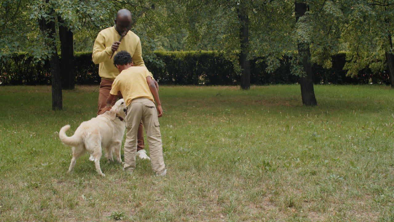 familia afroamericana jugando con un perro en el parque