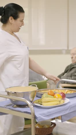 cook entering with food to the dining room of geriatric