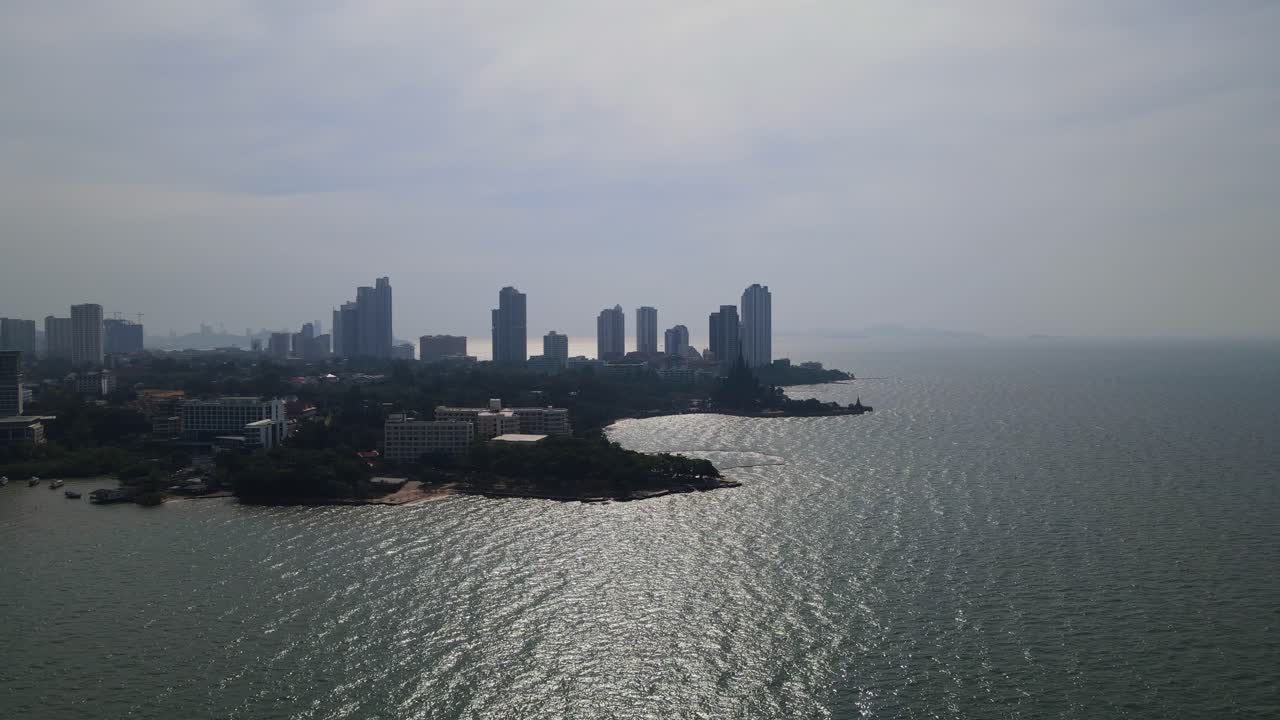 Ascending footage revealing the silhouette of the Sanctuary of Truth and buildings also beachfronts, Pattaya, Chonburi, Thailand