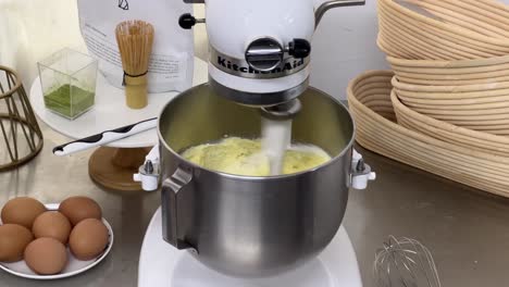 delicious cake making in progress, cake batter mixing in heavy duty electric mixer at commercial kitchen setting